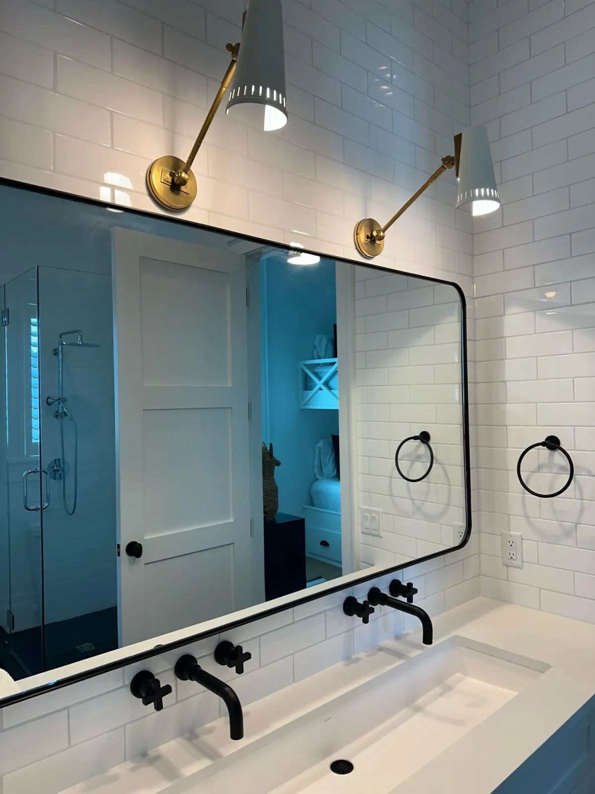 Finished bathroom with wall-mounted faucets and a tiled shower