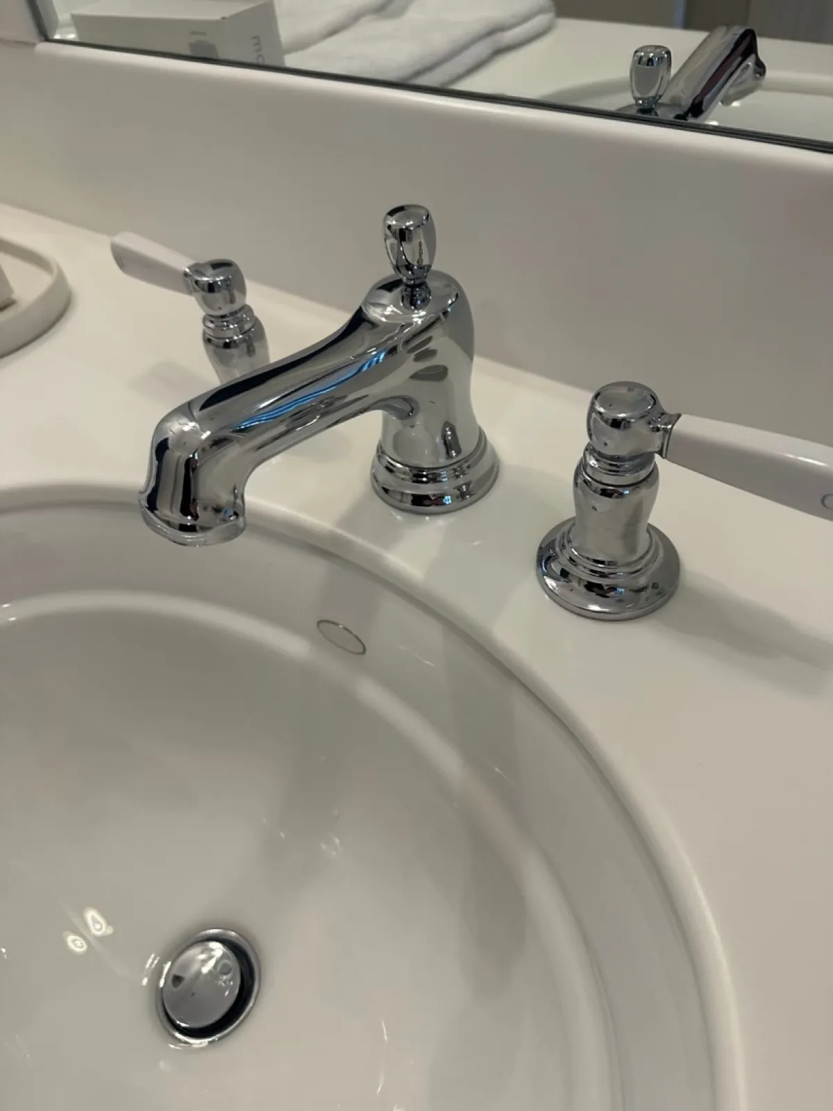Chrome widespread faucet on a white bathroom sink
