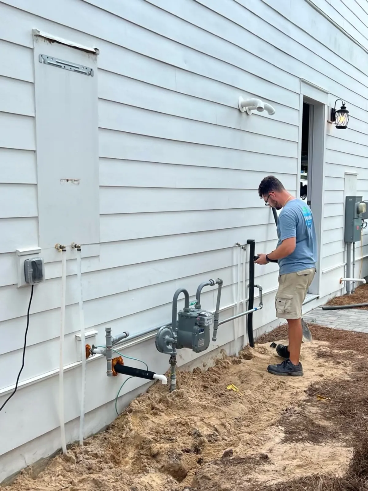 Technician connecting a gas meter and line on the exterior of a home