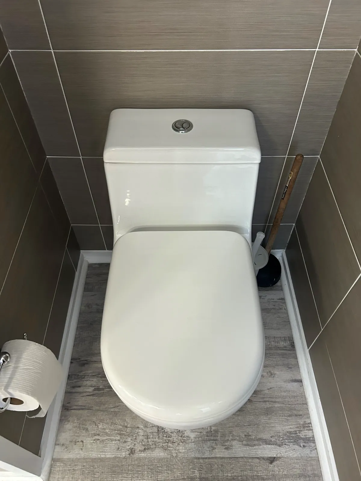 One-piece toilet installed in a tiled water closet